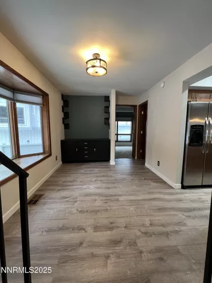 Dining area with window seat across from kitchen, built in storage in dining