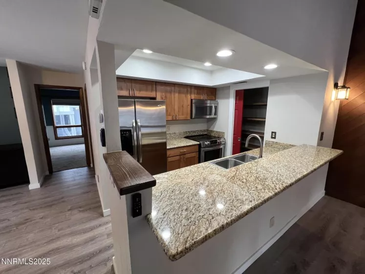 Kitchen with breakfast bar, SS appliances, granite counters, new cabinetry and pantry closet