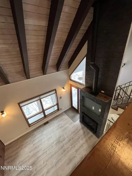View from Loft of Living/Great Room with stacked stone gas fireplace, lots of natural light