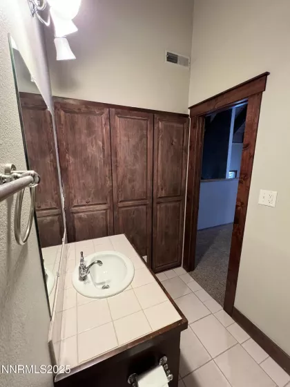 Loft full bathroom with convenient storage cabinets