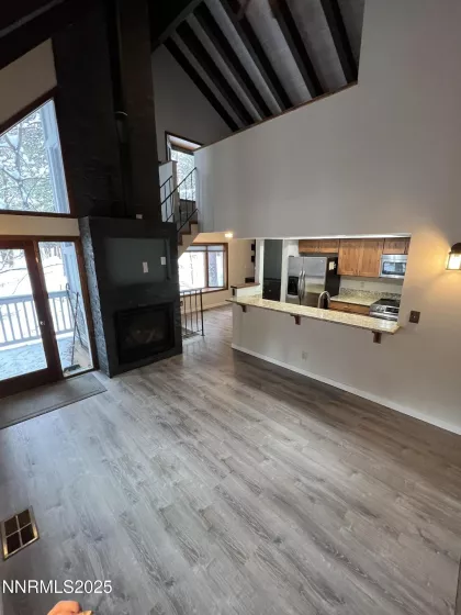 Living/Great Room with view to stacked stone fireplace and door to large expanded deck