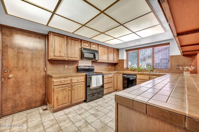 Spacious kitchen featuring charming vintage tile countertops with plenty of room to cook and gather.