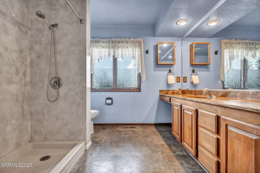 Luxurious primary bath with dual sinks, walk-in shower, ample storage, and bright natural light. Luxurious primary bath with dual sinks, walk-in shower.
