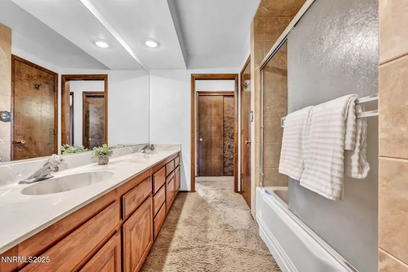 Guest bath boasts dual sinks, generous space and storage, plus a convenient shower/tub combo.
