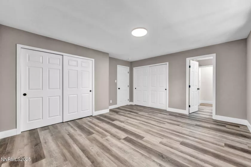 Primary bedroom showing two closets and entry to ensuite