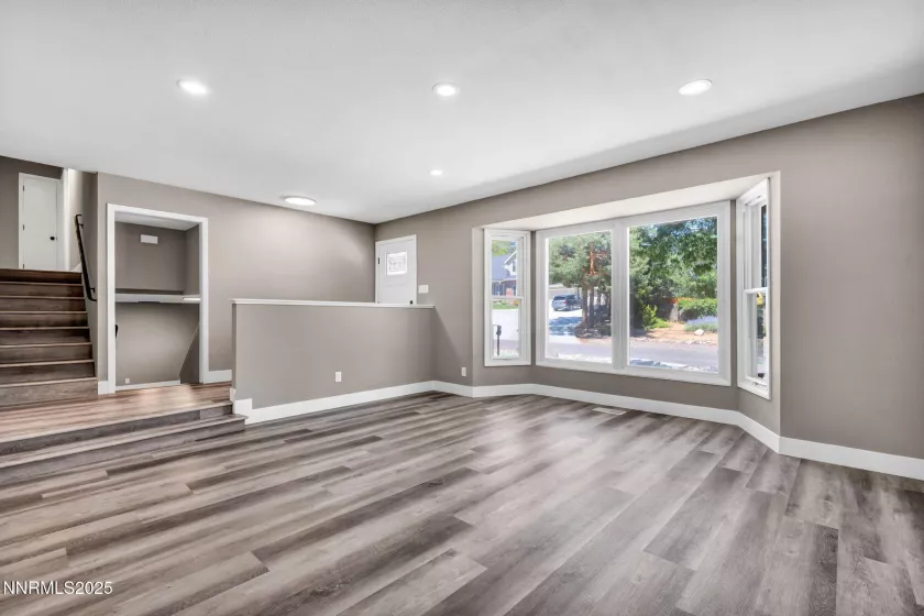 View of living room looking towards front entrance and large bay windows