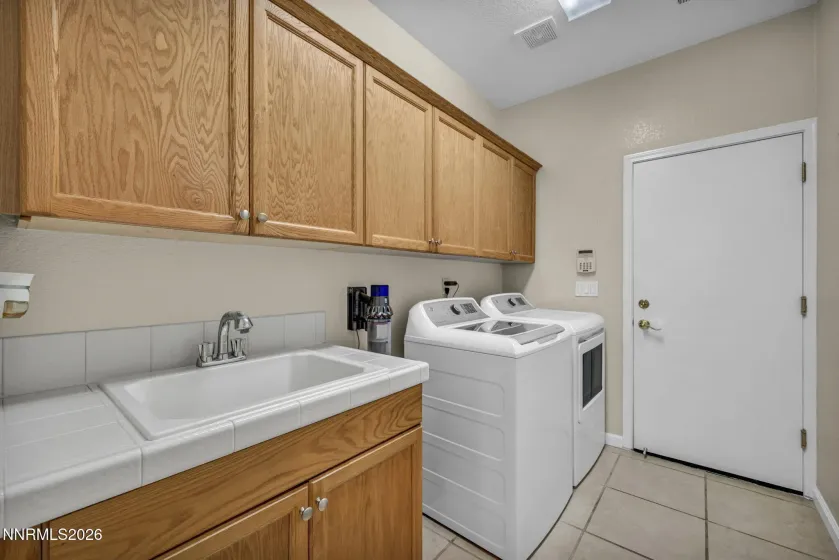 Laundry room with sink, counter and cabinets