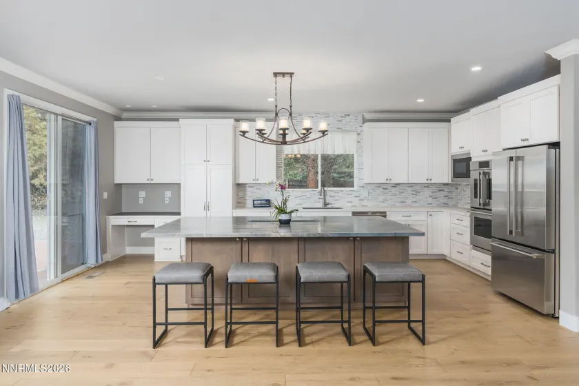 Oversized island with bar stools and slider out to the backyard