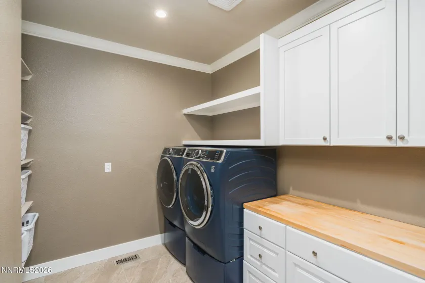 Laundry room with top of the line washer and dryer and plumbed for sink. Custom cabinets and storage