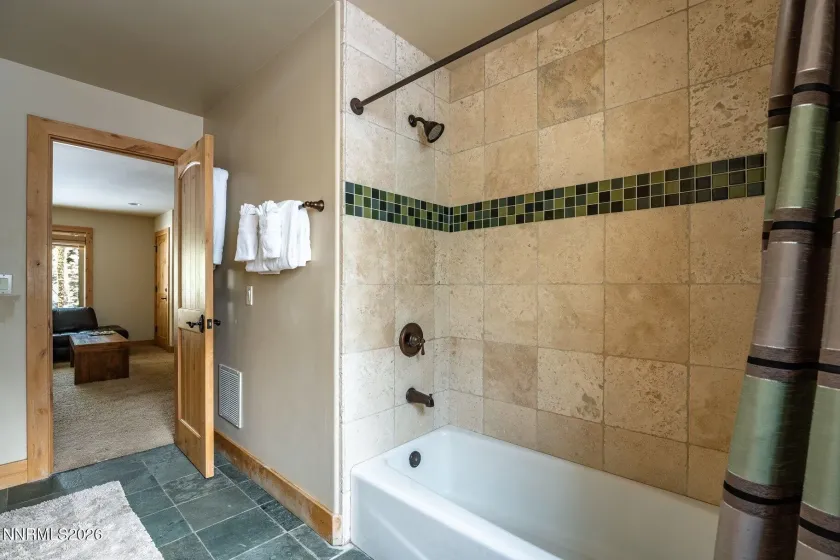 Full bathroom featuring a tiled tub and shower surround.