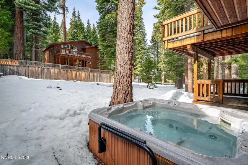 Private outdoor hot tub surrounded by towering pines for year-round relaxation.