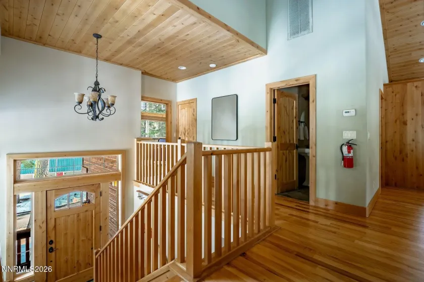Open upper-level landing with warm wood finishes and abundant natural light.
