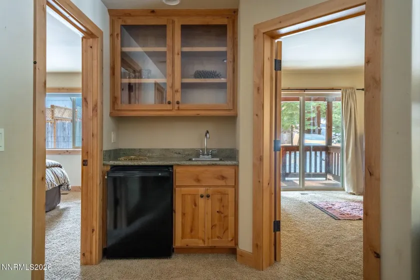 Convenient wet bar with built-in cabinetry and beverage refrigerator.