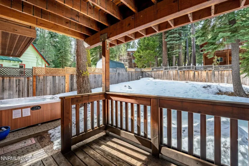 Private outdoor living space overlooking the hot tub and forested setting.