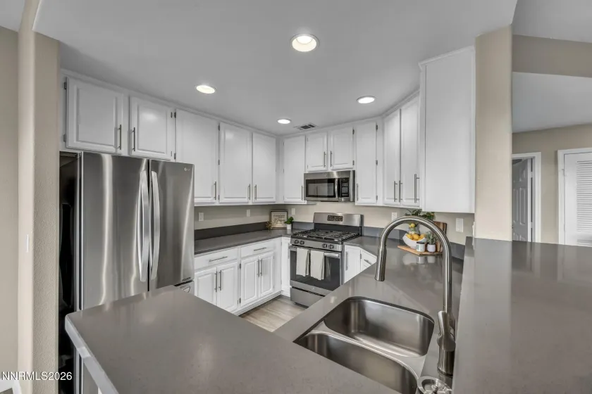 Kitchen View from Breakfast Bar – View of the kitchen from the breakfast bar showcasing the cabinetry, countertops, and open layout designed for casual dining and entertaining.