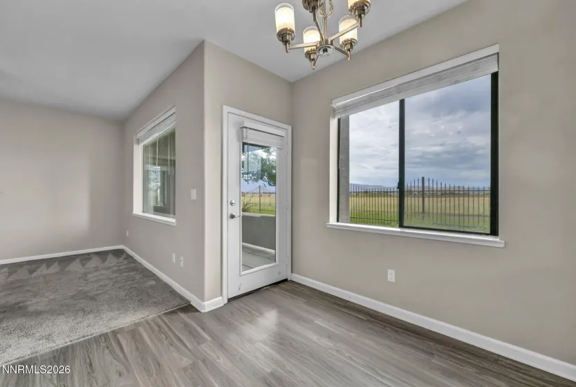 Kitchen Nook View – View from the kitchen nook showcasing a glimpse of the living room and convenient access door to the patio, highlighting the open and connected floor plan.