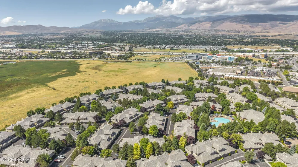 Aerial view showcasing the peaceful meadow and walking trail directly behind the condo, highlighting the home's private setting and beautiful natural surroundings with Mount Rose in the distance.