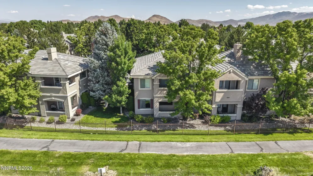Aerial view showcasing the peaceful meadow and walking trail directly behind the condo, highlighting the home's private setting and beautiful natural surroundings.