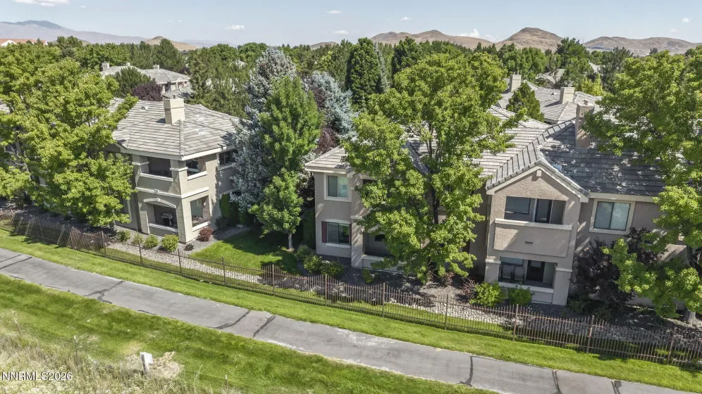 Aerial view showcasing the peaceful meadow and walking trail directly behind the condo, highlighting the home's private setting and beautiful natural surroundings.