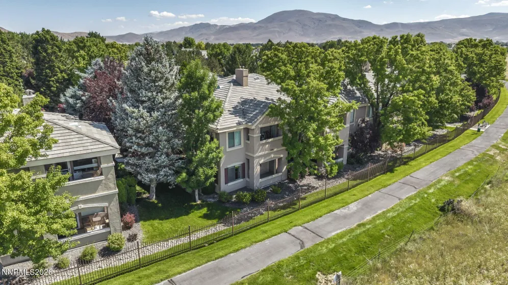 Aerial view showcasing the peaceful meadow and walking trail directly behind the condo, highlighting the home's private setting and beautiful natural surroundings.