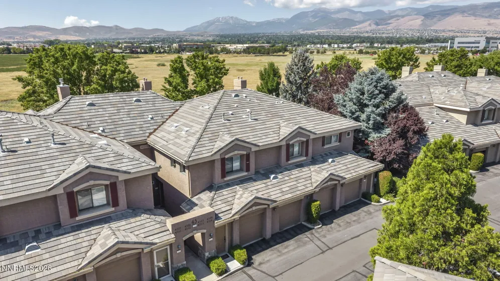 Aerial view of the front of the condo showcasing its prime location with open meadow views and the stunning Mount Rose mountain range, highlighting the peaceful setting and scenic surroundings.