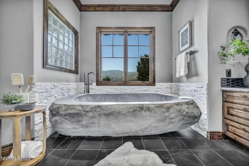 Soaking Natural Stone Bathtub In Primary Bathroom