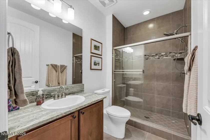 Upgraded granite and accent tile in the guest bath.