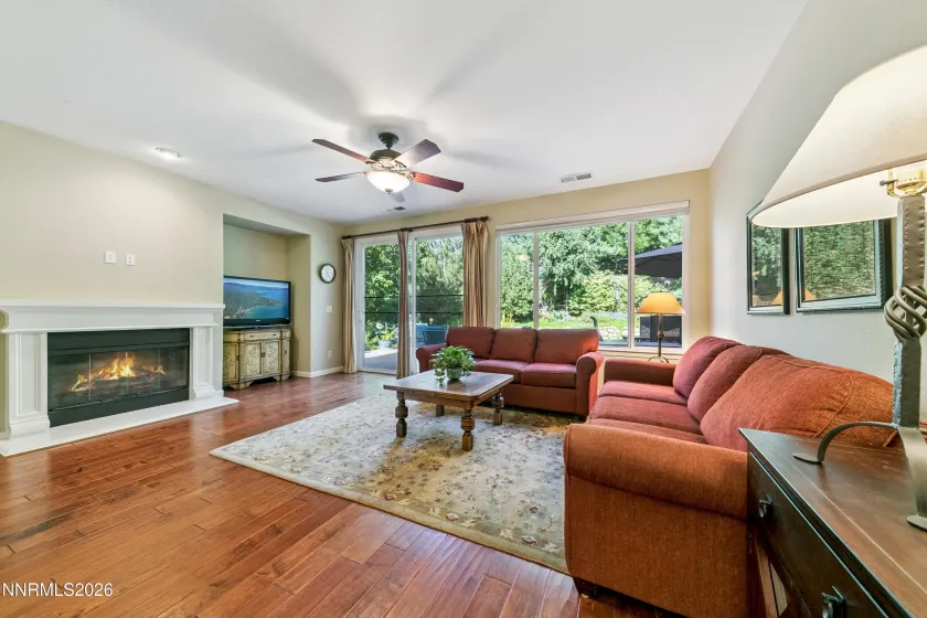 Spacious family room with high ceilings and a sliding glass door opening to the beautifully landscaped backyard, creating an inviting connection between indoor and outdoor living.