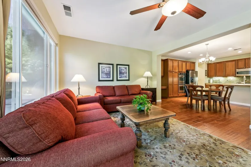 Spacious family room with high ceilings and a sliding glass door opening to the beautifully landscaped backyard, creating an inviting connection between indoor and outdoor living.