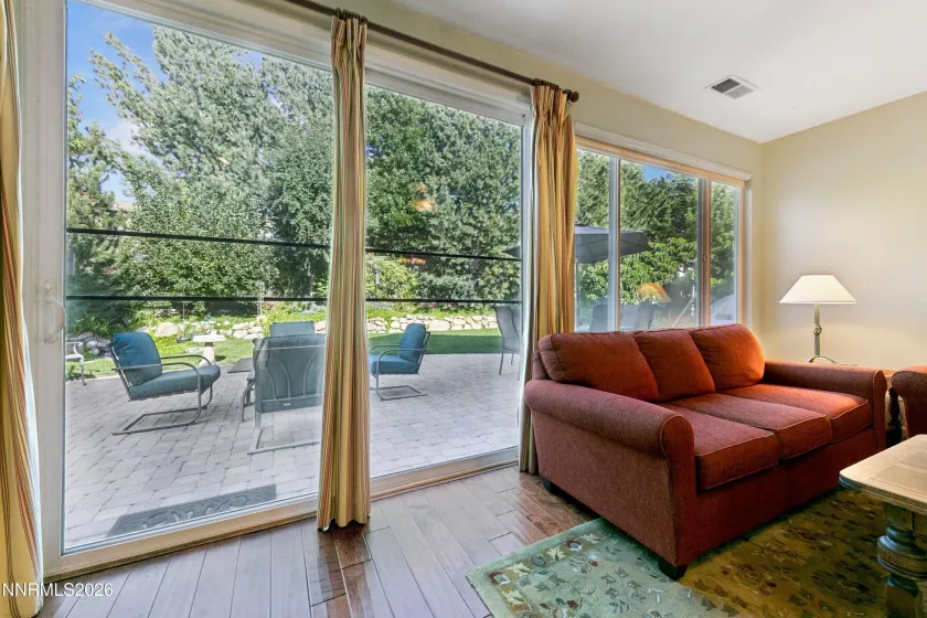 Spacious family room with high ceilings and a sliding glass door opening to the beautifully landscaped backyard, creating an inviting connection between indoor and outdoor living.