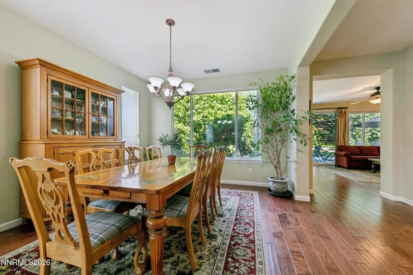 Light-filled formal dining area with abundant windows, creating a bright and inviting setting, conveniently adjacent to the elegant formal sitting/living room.