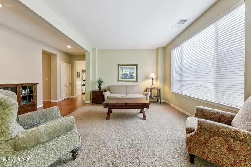Light-filled formal sitting/living room with abundant natural light, thoughtfully positioned adjacent to the dining area—an inviting layout designed for gatherings and entertaining.