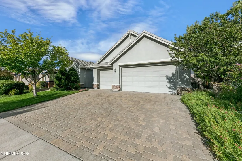 Welcoming curb appeal with lush landscaping and a beautiful paver driveway leading to this well-maintained South Reno home.