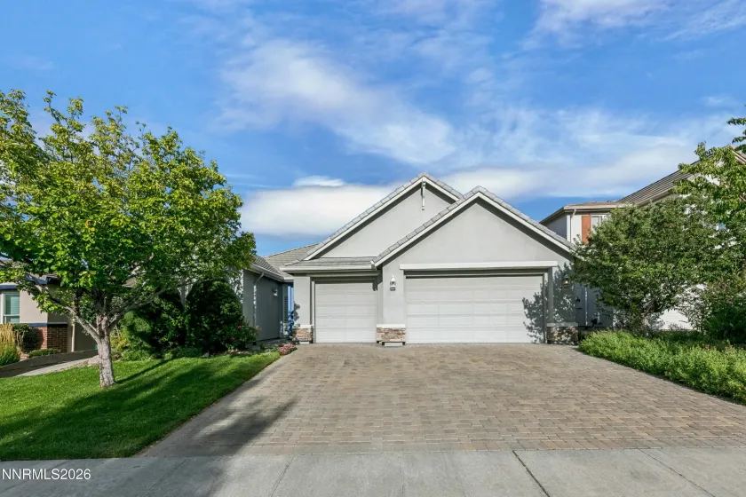 Welcoming curb appeal with lush landscaping and a beautiful paver driveway leading to this well-maintained South Reno home.