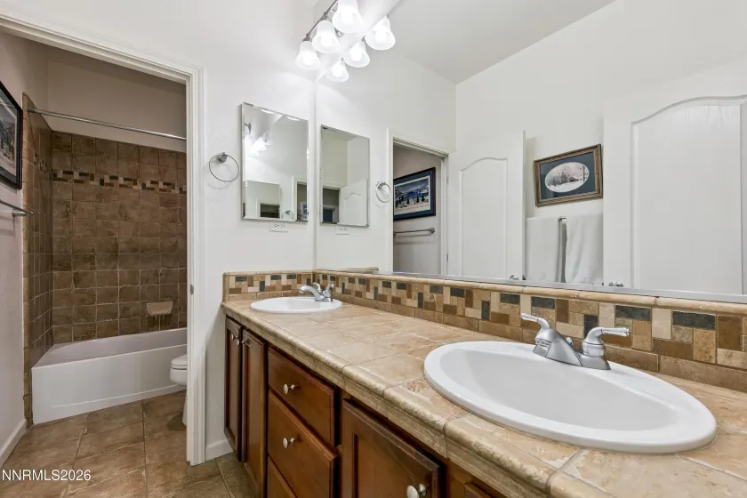 Spacious shared full bathroom serving two bedrooms, featuring a dual-sink vanity and a separate shower area for added privacy and functionality.