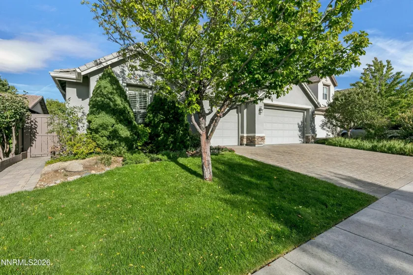 Welcoming curb appeal with lush landscaping and a beautiful paver driveway leading to this well-maintained South Reno home.