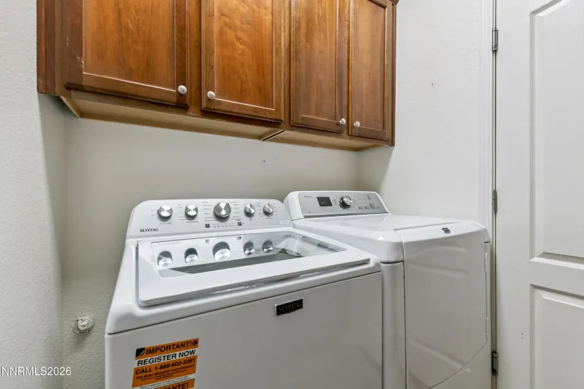 Dedicated laundry room with ample shelving, cabinetry, and a utility sink for added convenience and functionality.