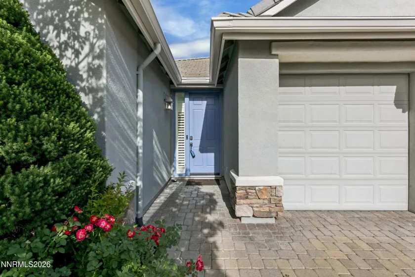 Welcoming curb appeal with lush landscaping and a beautiful paver driveway leading to this well-maintained South Reno home.