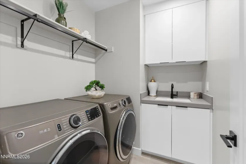 Laundry room, washer and dryer stay, sink, cabinets.