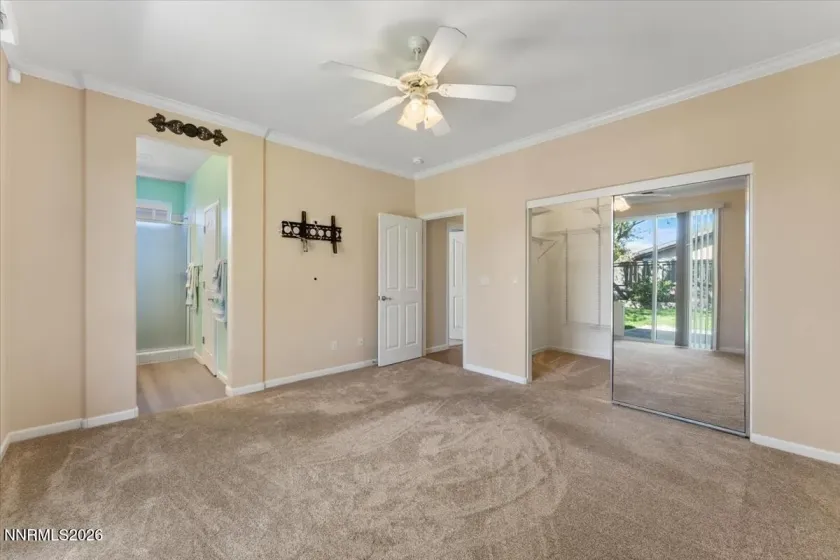 Primary bed with large walk in closet, new carpet and crown moulding.