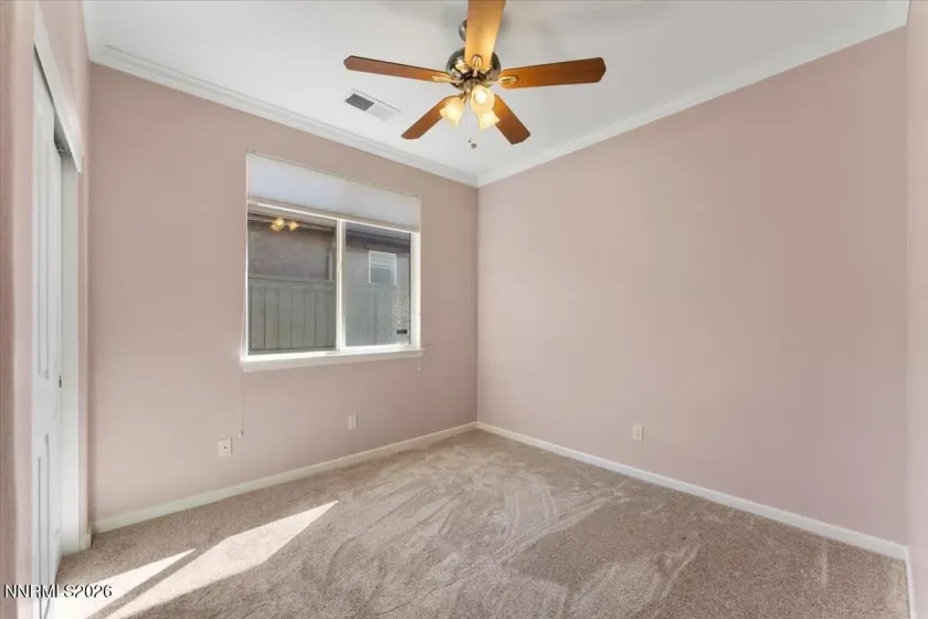 Bedroom 3 with ceiling fan and crown moulding