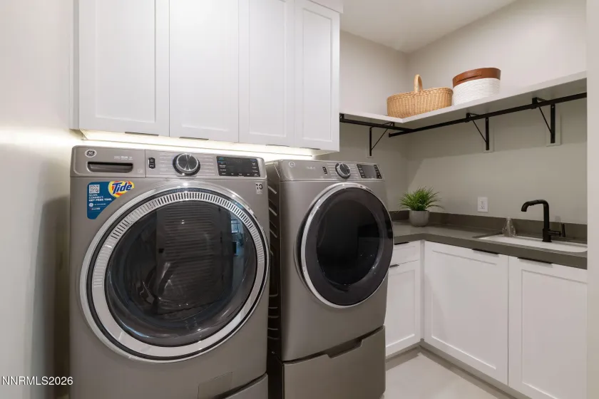 Laundry room with soft close cabinetry, Washer and Dryer with pedestals and laundry sink